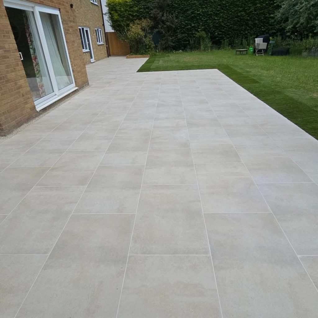 Large light grey porcelain patio beside a new lawn